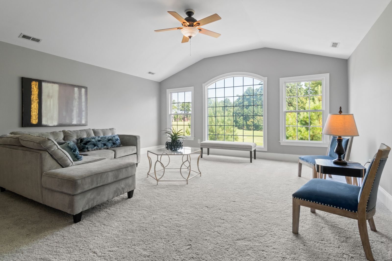 Contemporary living room in neutral tones with large windows.