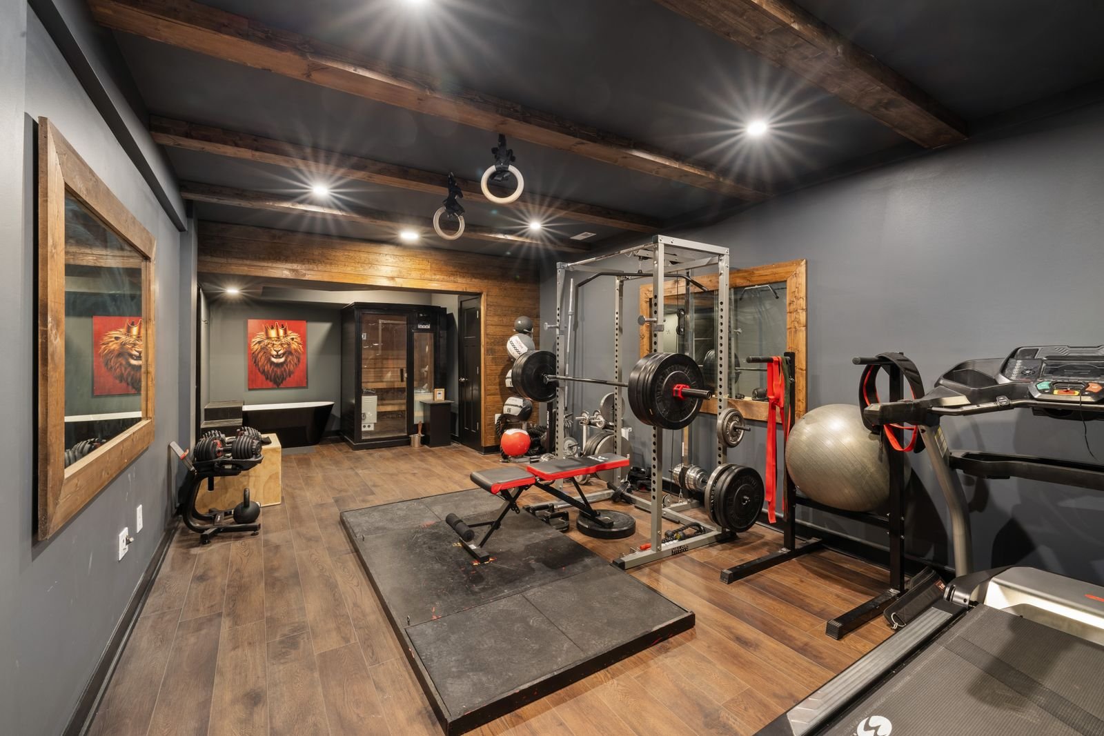 Modern home gym with weights, a treadmill and other fitness equipment.