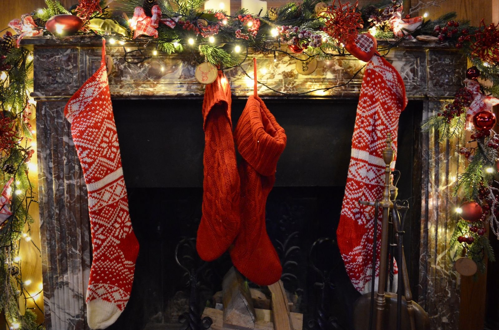 Fireplace decorated with Christmas stockings and twinkling lights.