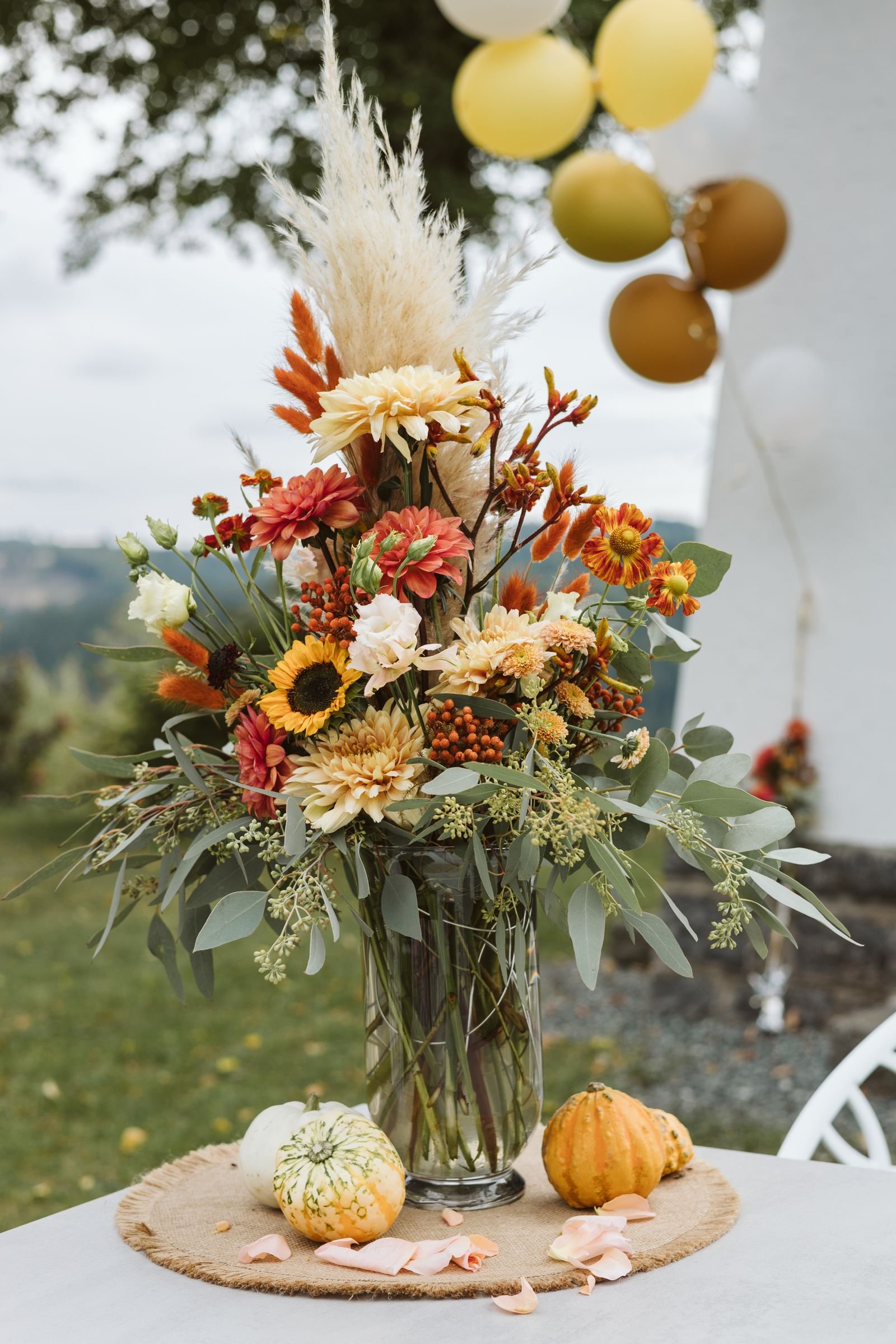 Autumn floral centerpiece with pumpkins and dried pampas grass.