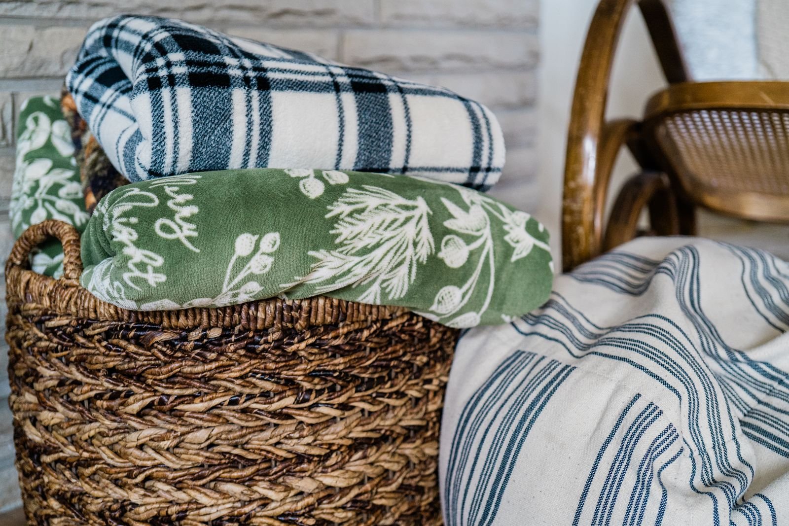 Wicker basket filled with soft folded blankets.
