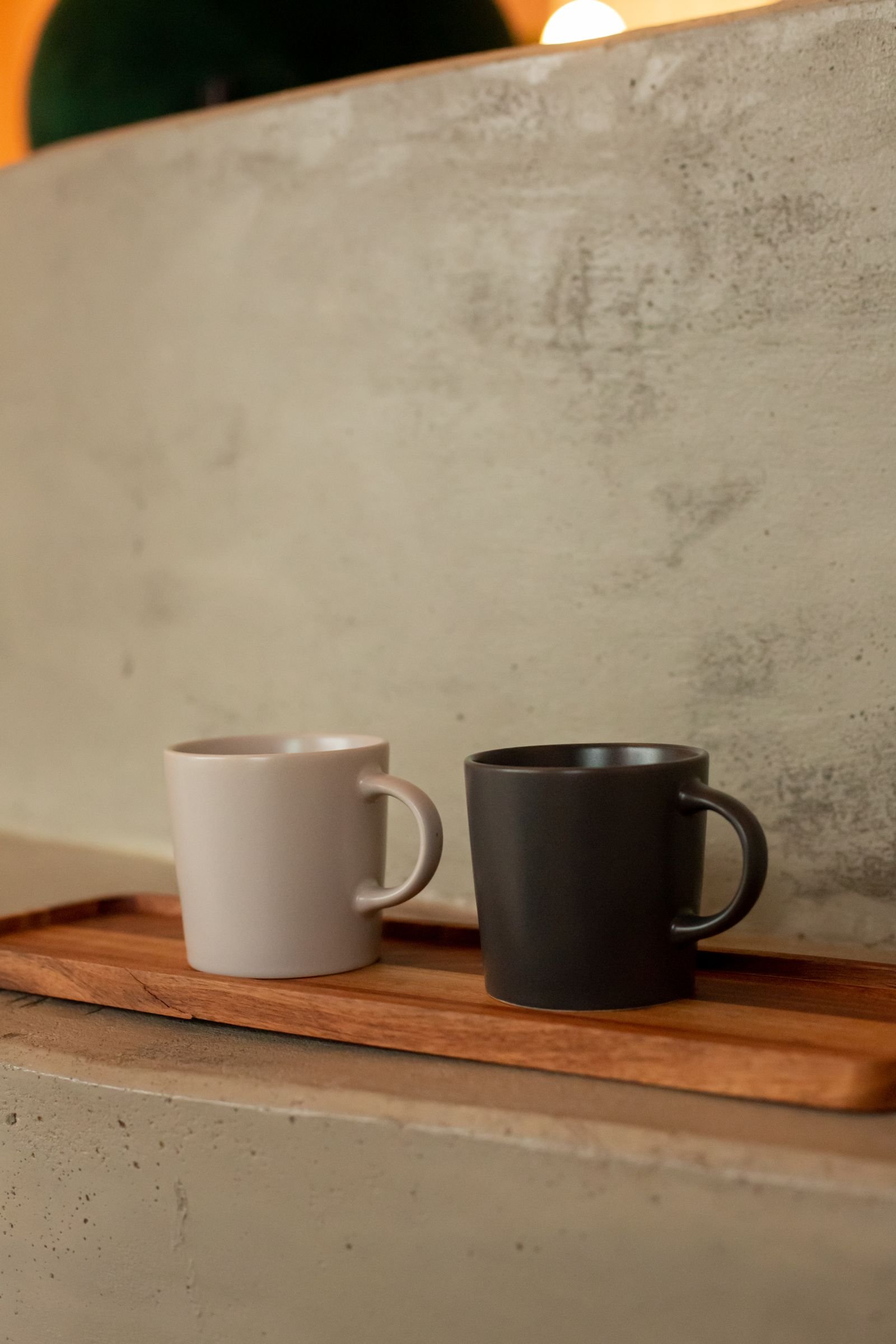 Gray and white ceramic mugs on a wooden tray.