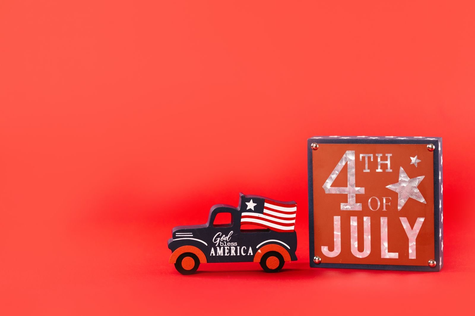 Vintage toy truck with a flag and a 4th of July sign.