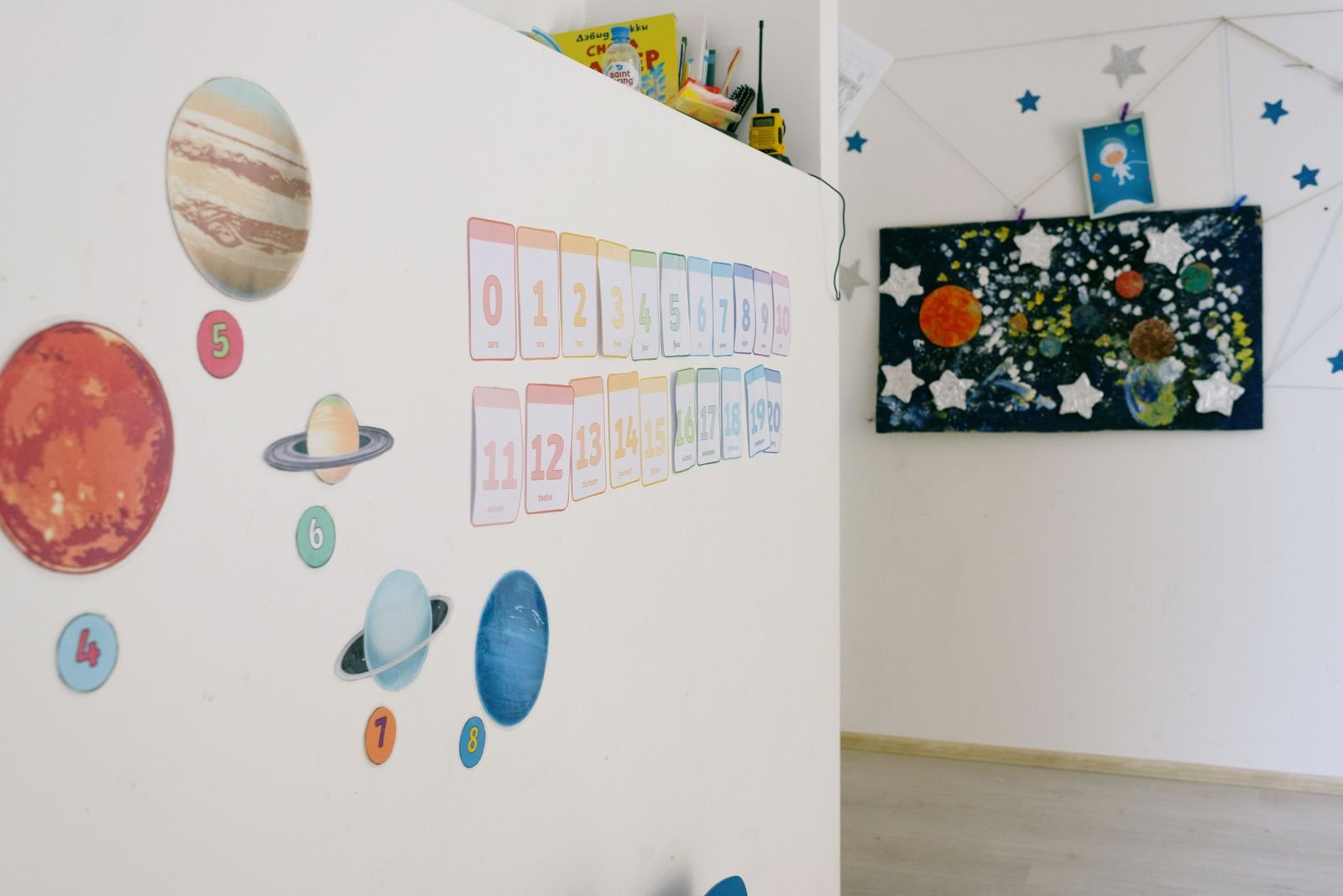 Classroom wall decorated with planet cutouts and numbers.