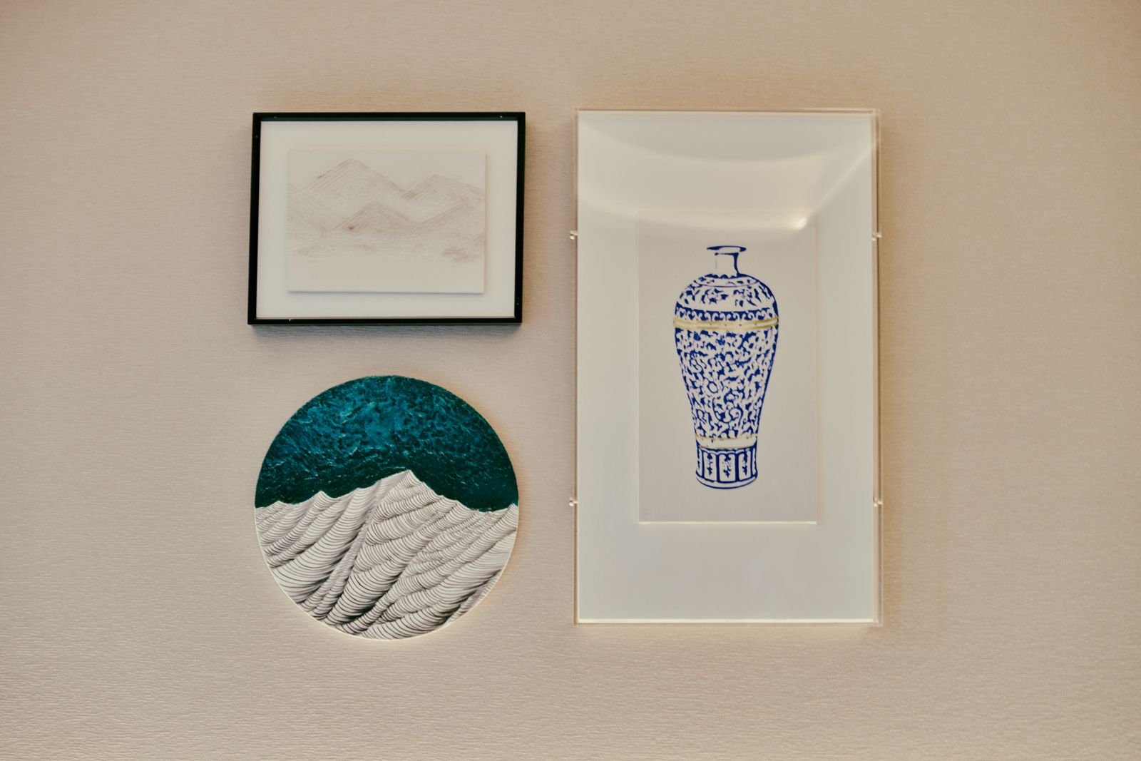 Framed minimalist art pieces arranged on a textured wall.