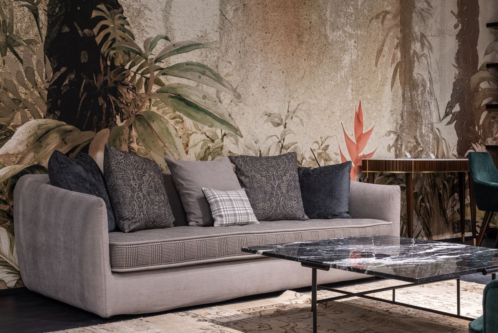 Sofa with pillows in a spacious living room with a table on a rug.