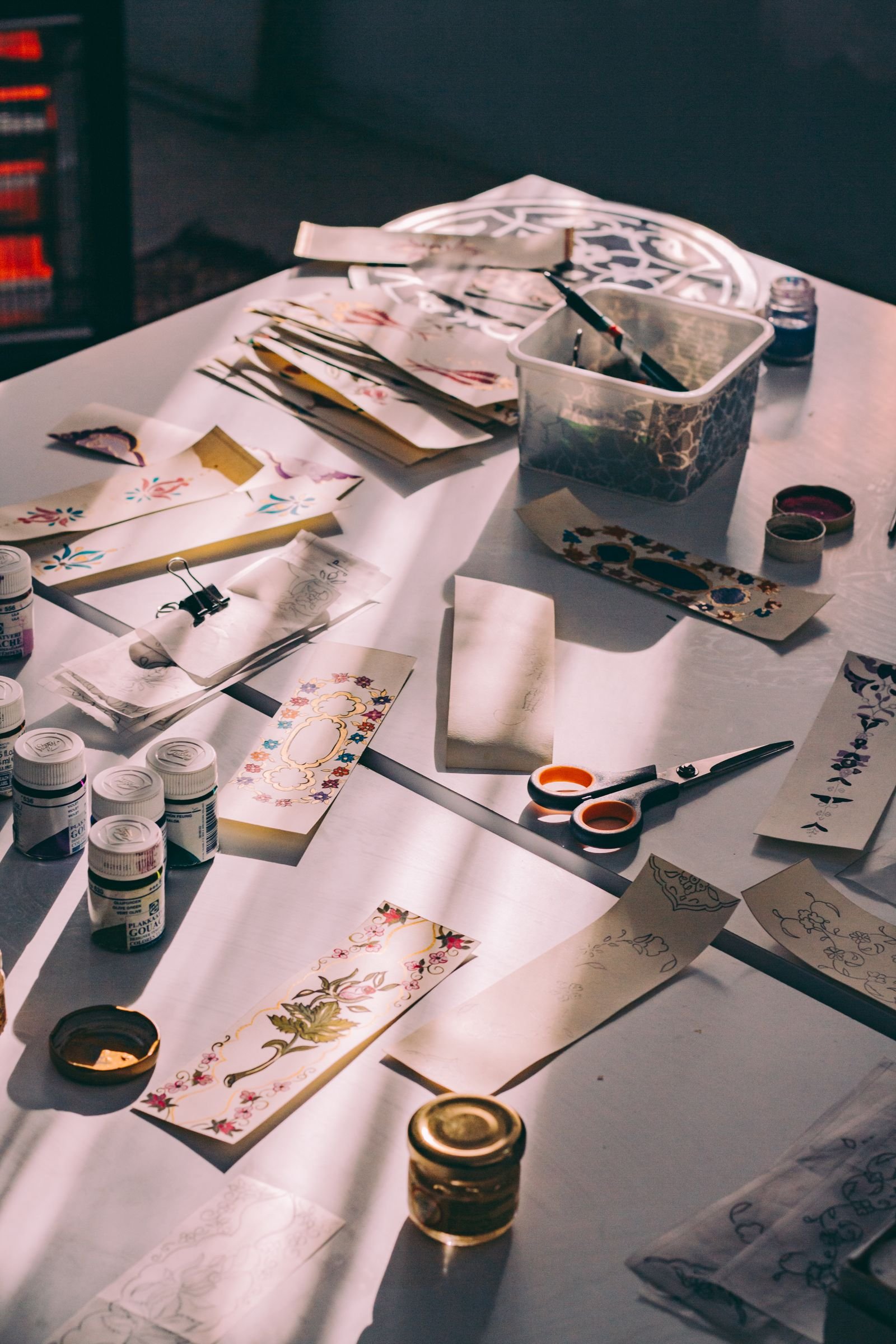 Crafting materials and tools laid out on a sunlit table.