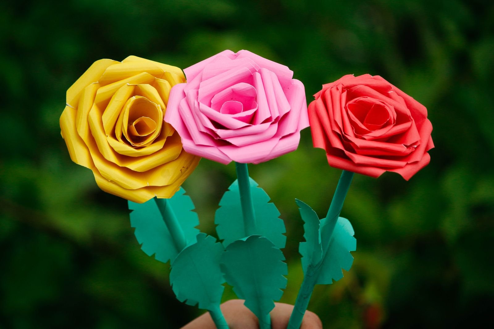 Close-up of handmade paper roses in several bright colors.