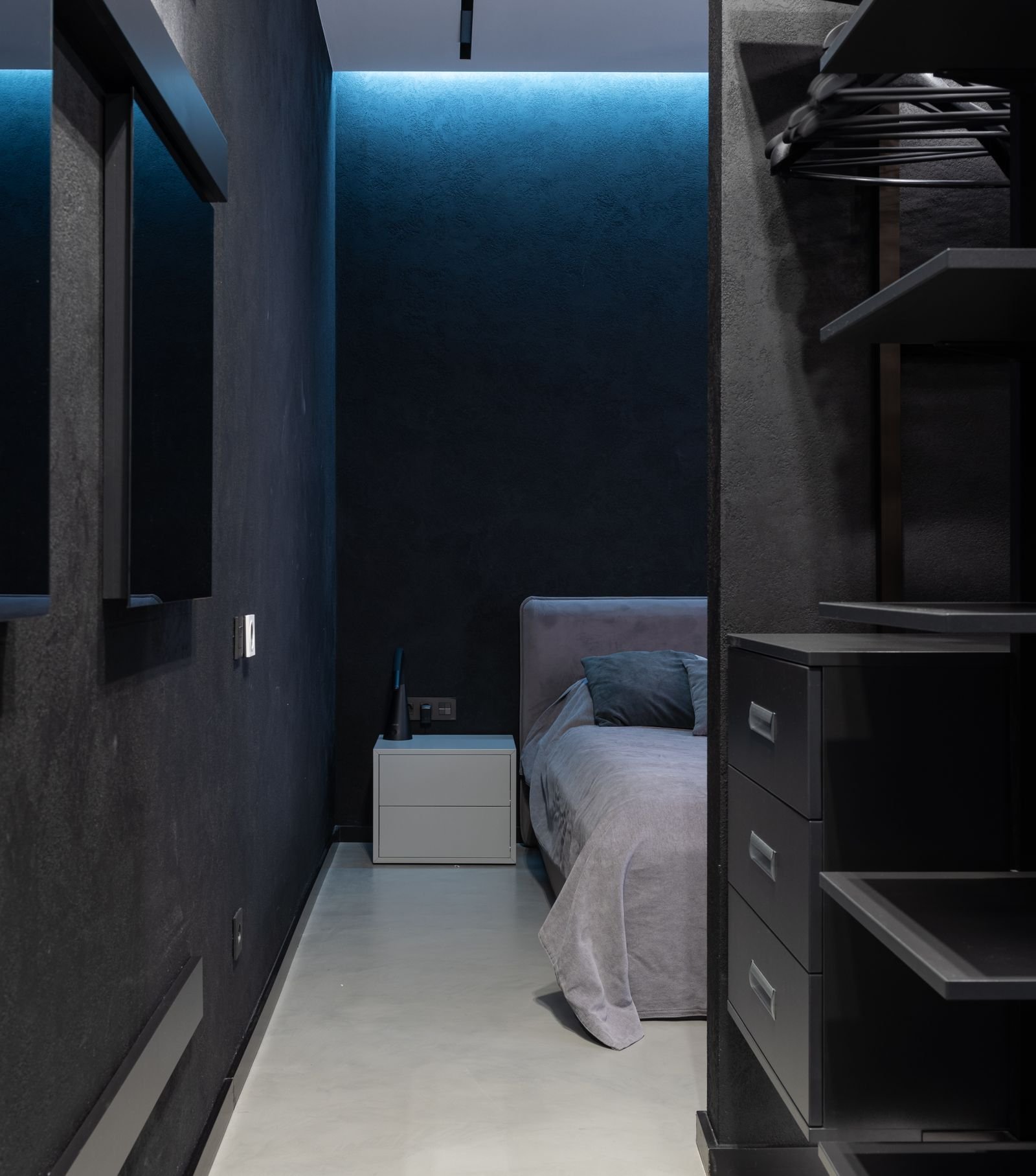 Contemporary bedroom with an open wardrobe, shelves and a built-in desk.