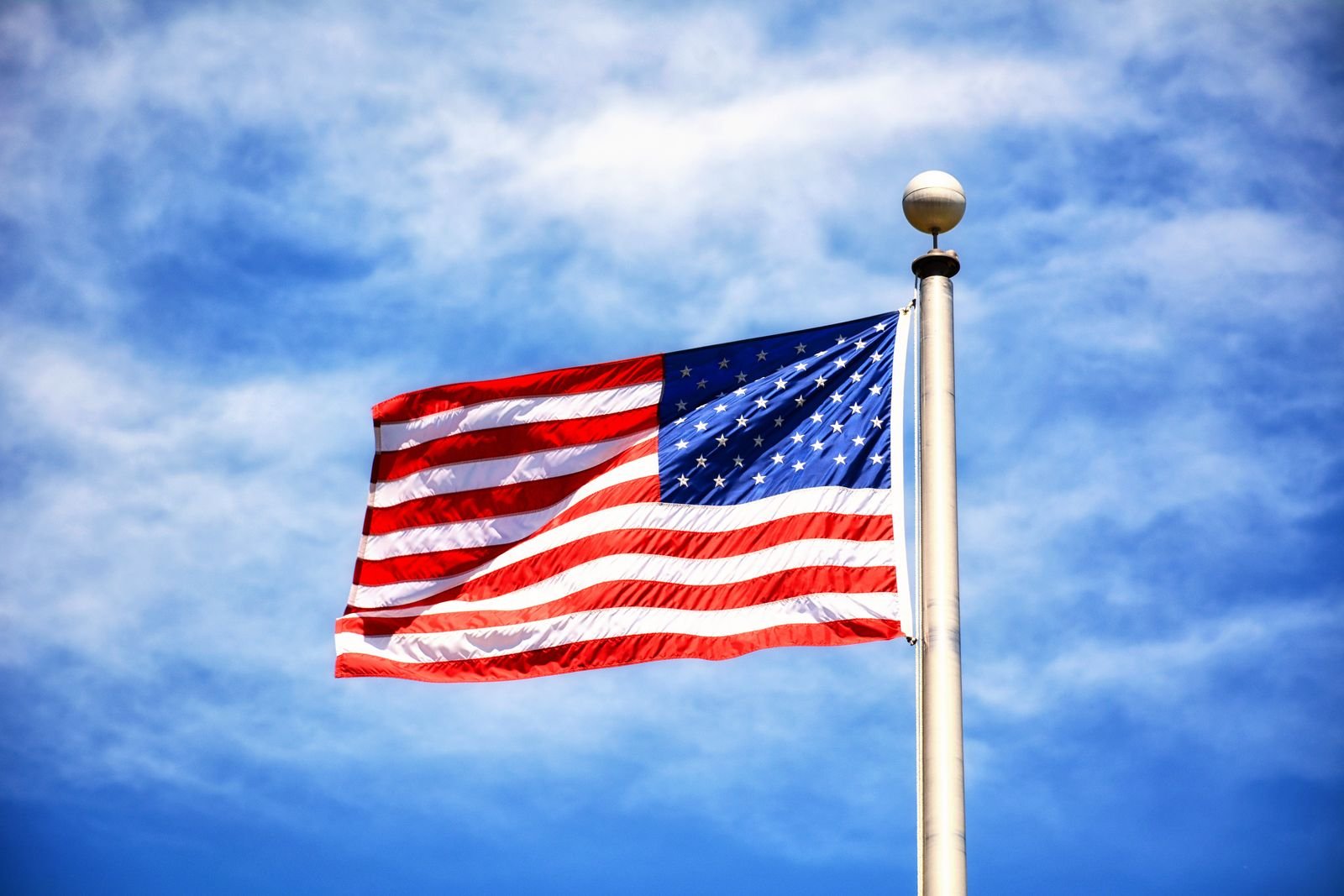 American flag on a pole against a clear blue sky.