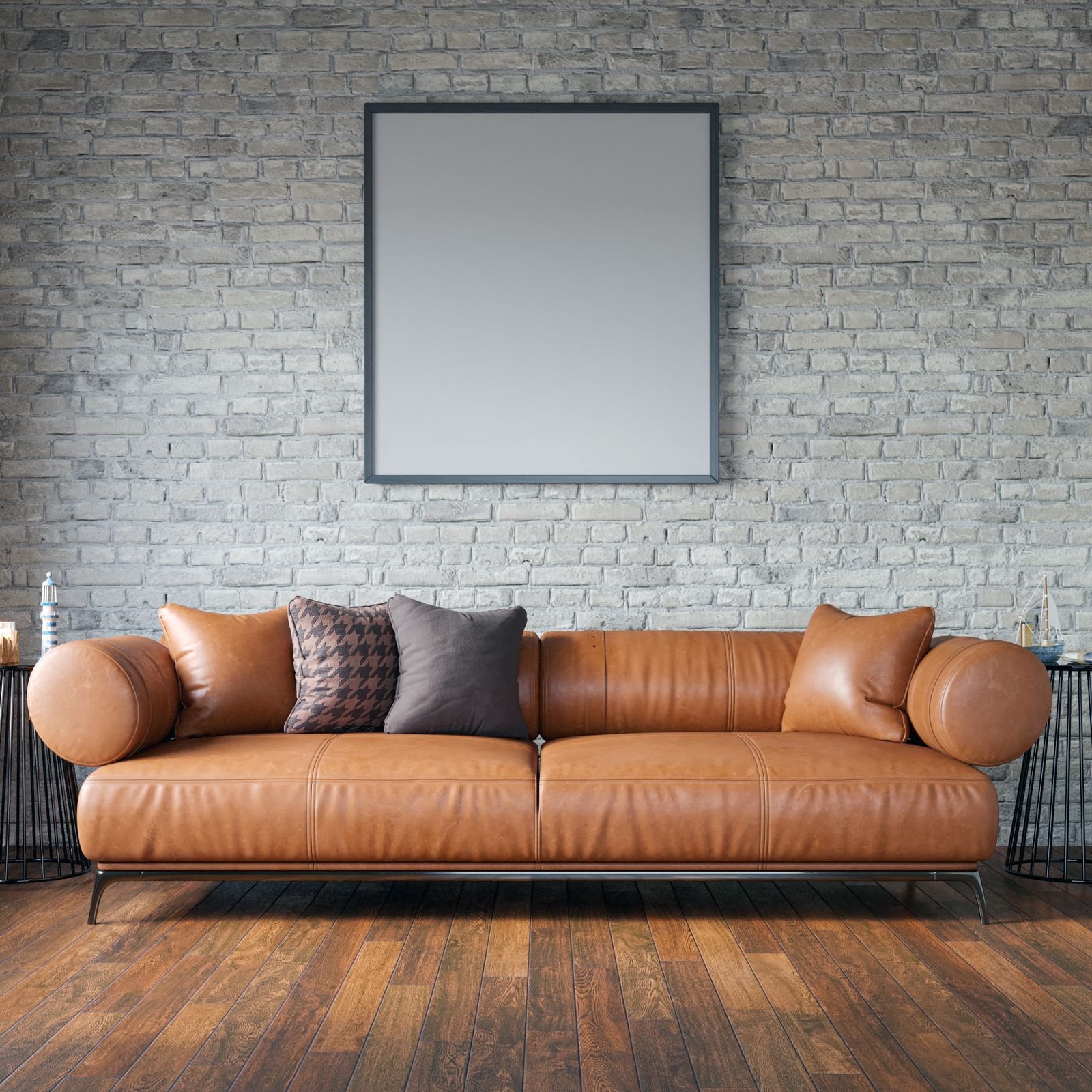 Leather sofa against a brick wall in a living room with wood floors.