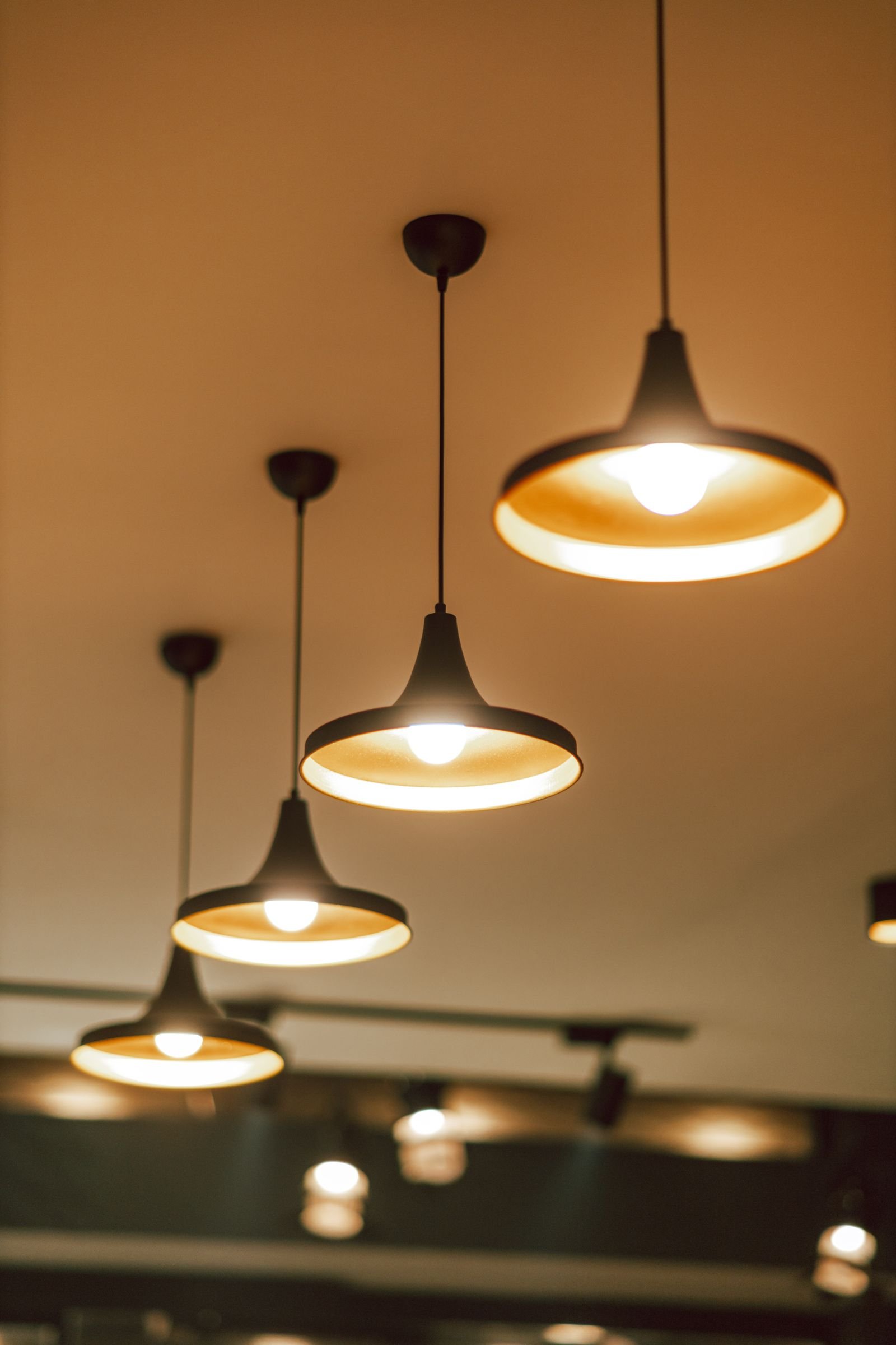 Row of modern pendant lights glowing warmly indoors.