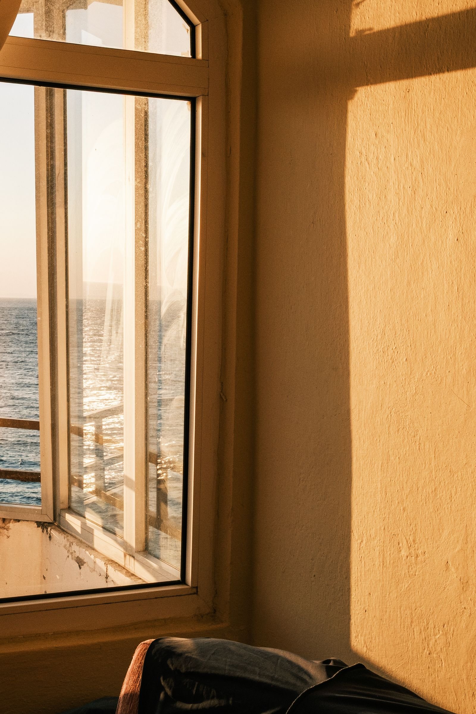 Sunlit room with an ocean view through the window.
