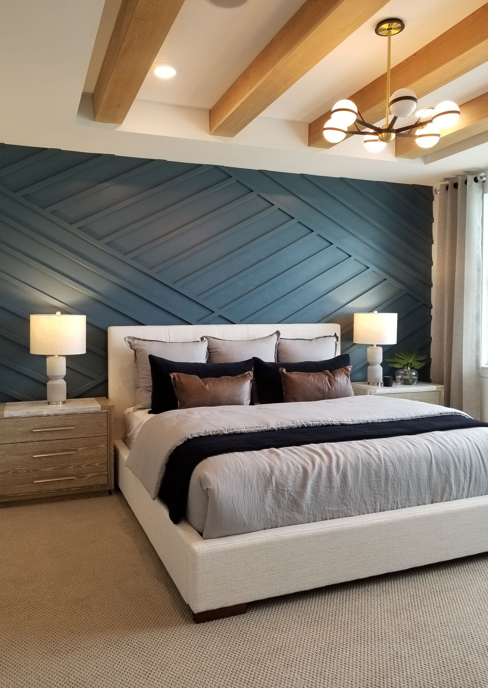 Contemporary bedroom with a blue accent wall and wood accents.