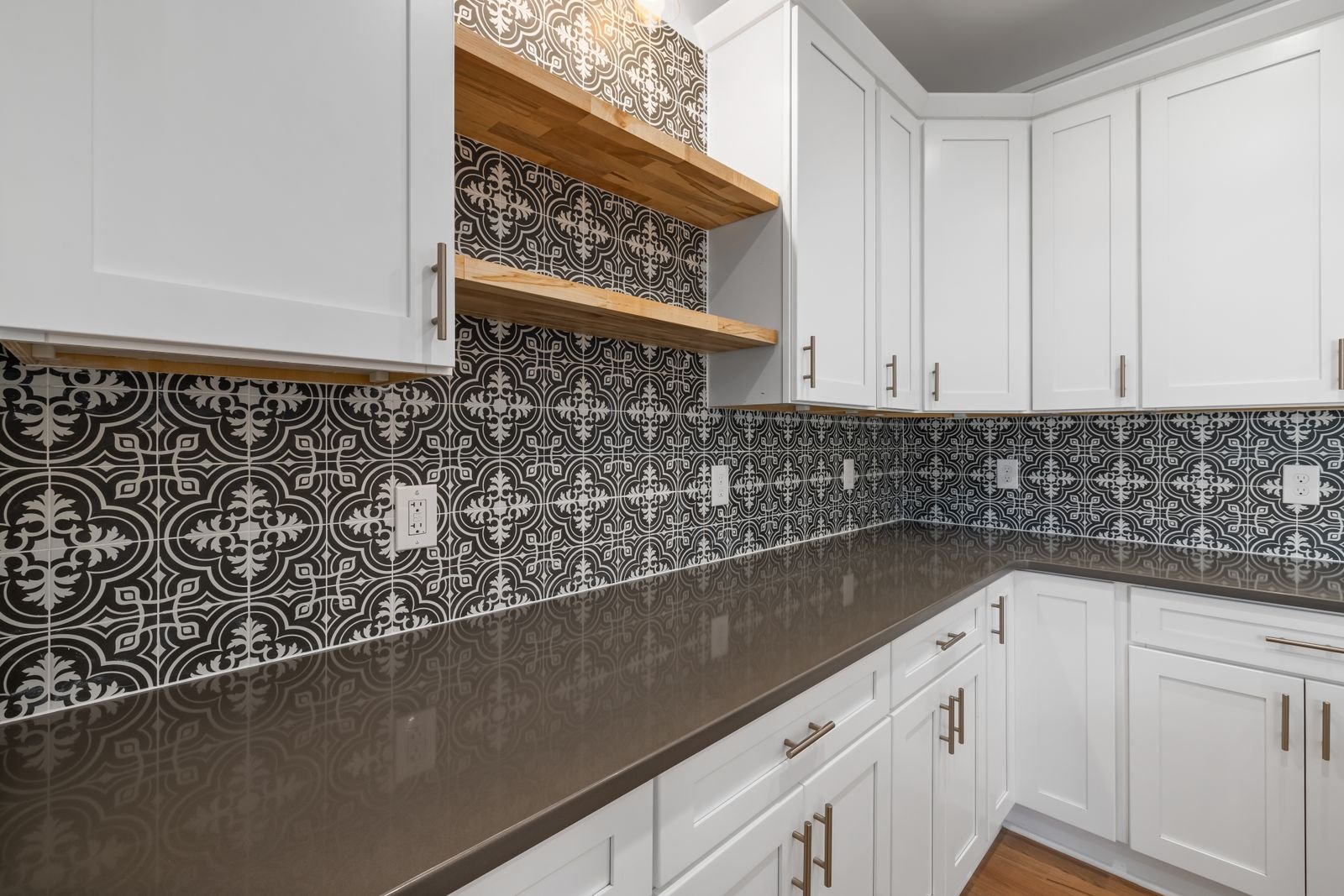 Kitchen with white cabinets and a geometric patterned tile backsplash.