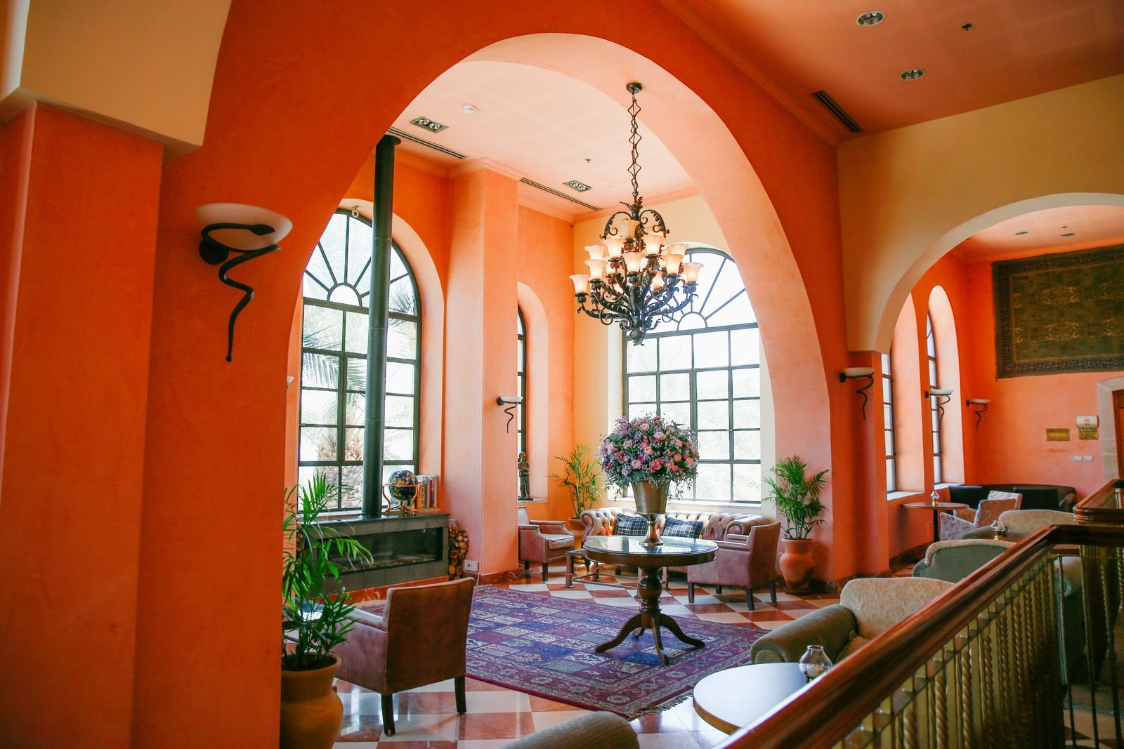 Bright Mediterranean-style living room with arched windows and flowers.