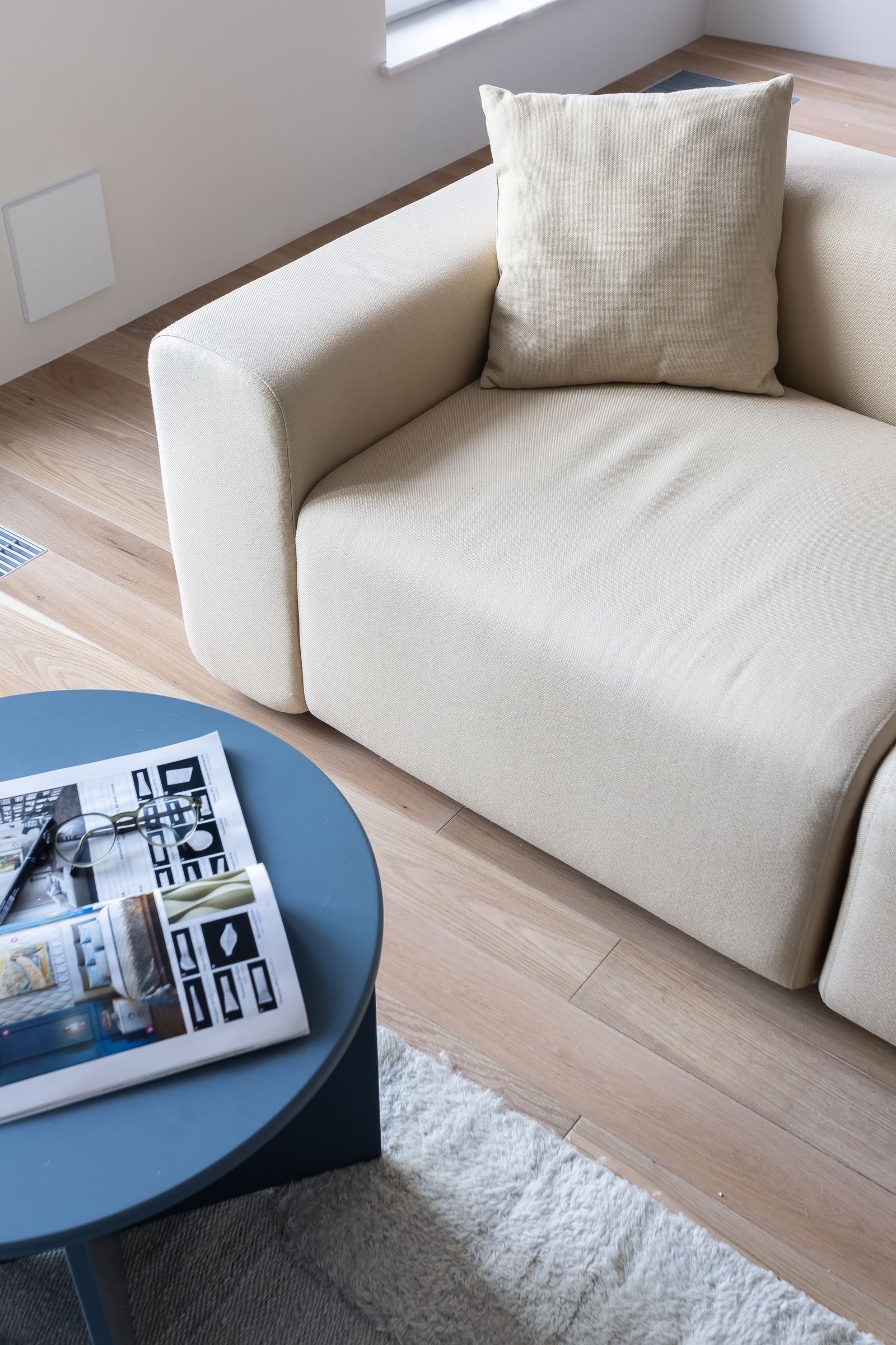 Minimalist living room with a beige sofa and soft neutral tones.