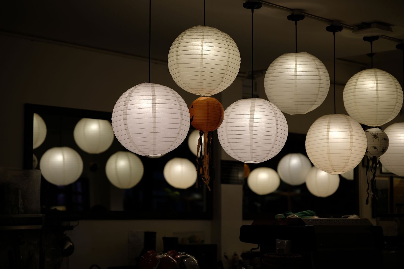Round paper lanterns glowing warmly in an indoor room.