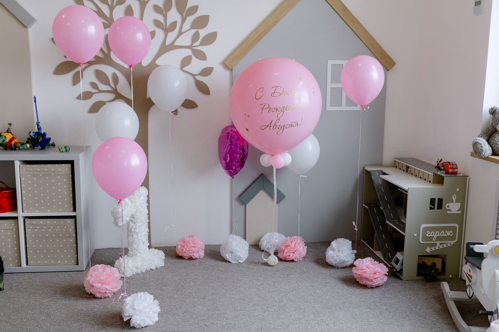Pink balloons and playful decorations for a child's birthday.