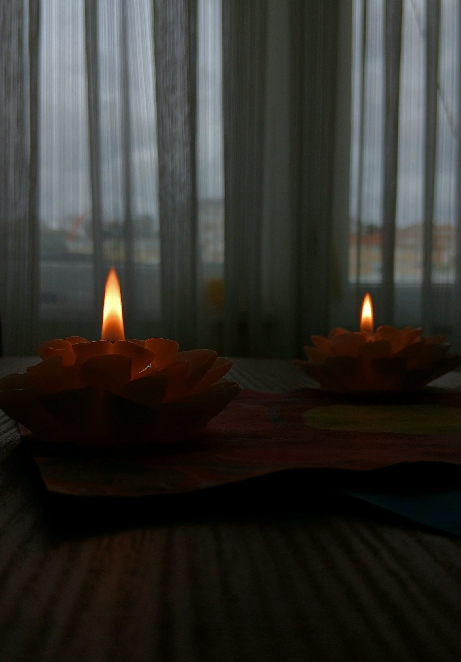 Decorative candles casting a warm glow on a wooden table.