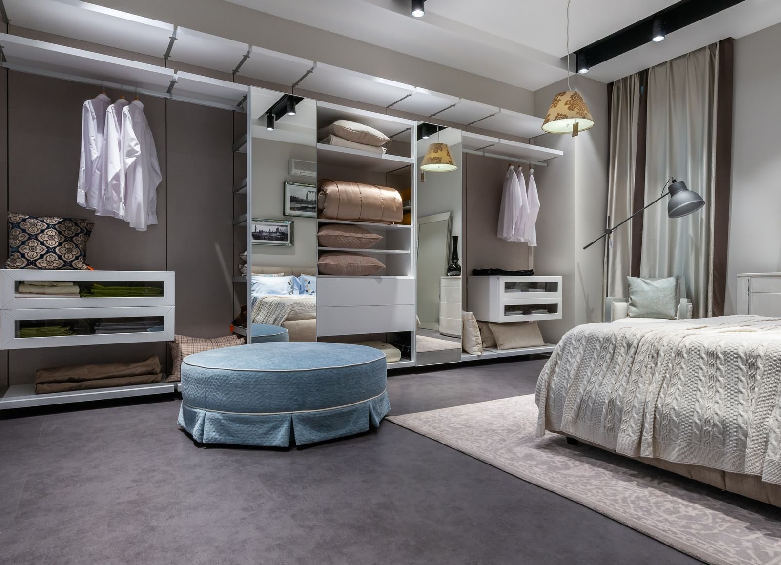 Modern bedroom with a built-in wardrobe, carpet and padded stool.