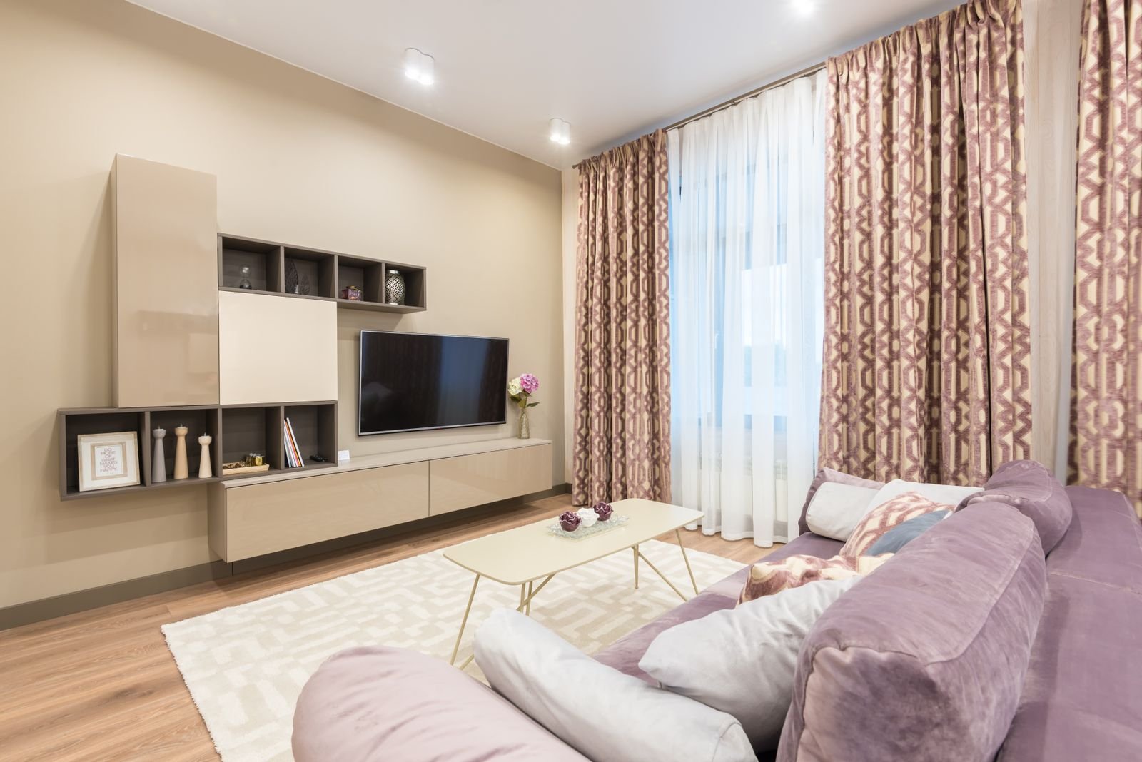 Compact living room with a sofa, cushions, coffee table and cabinet.