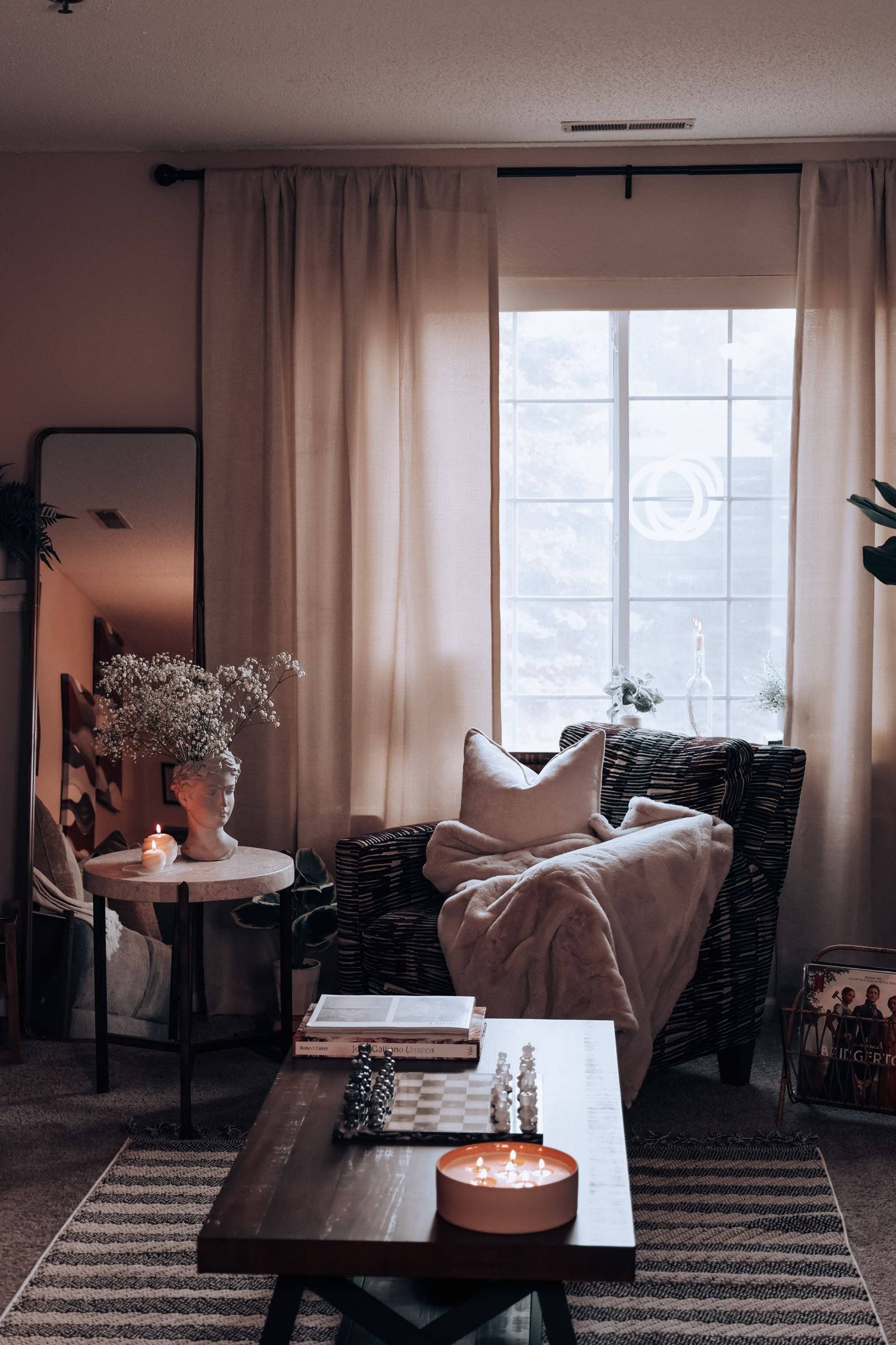 Cozy living room with warm lighting, a wicker armchair and decor.