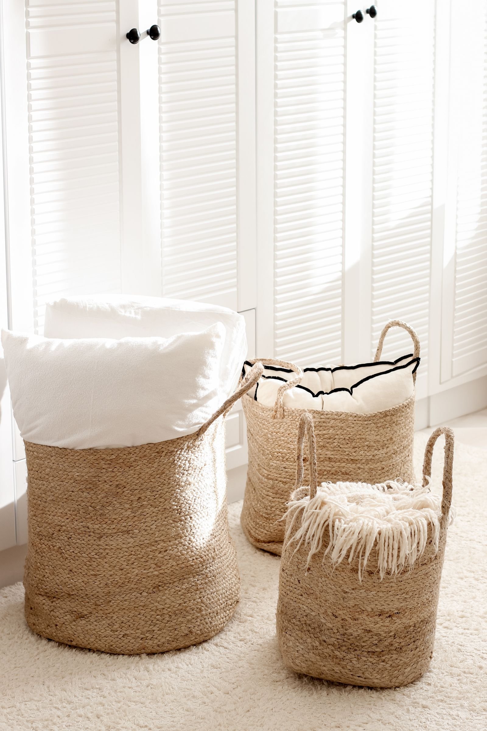 Wicker baskets with soft textiles in a sunlit room.