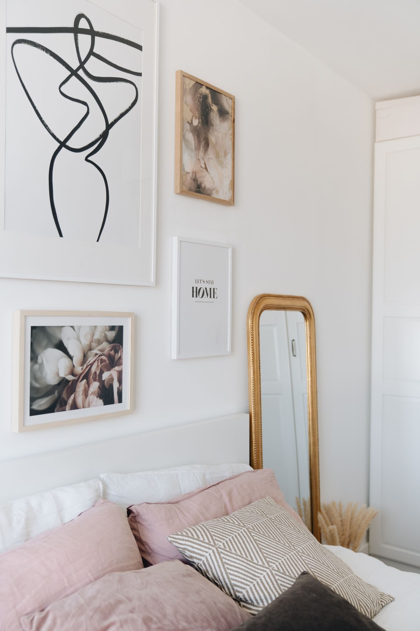 Elegant bedroom with framed artworks hanging on the wall.