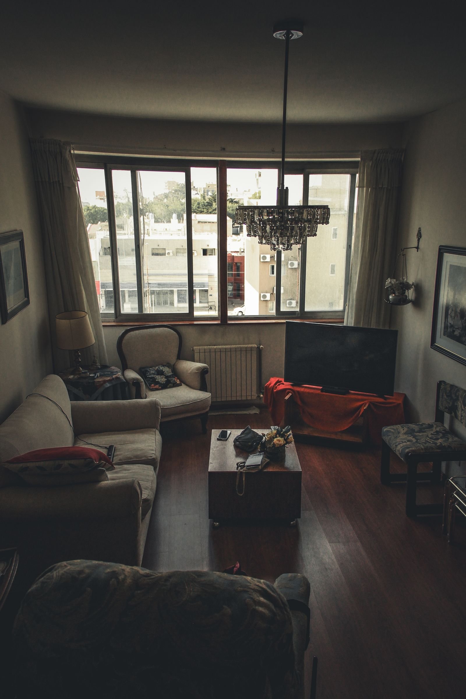 Cozy living room with vintage furniture and a large window.