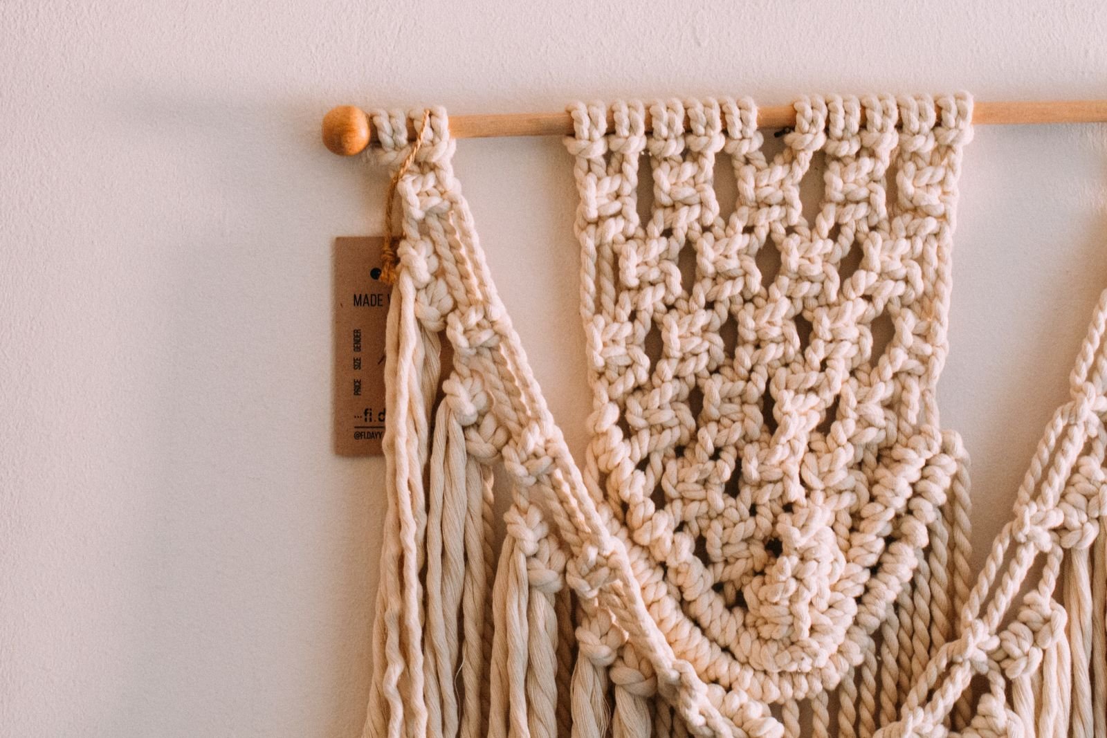 Handmade beige macrame wall hanging with intricate knots and patterns