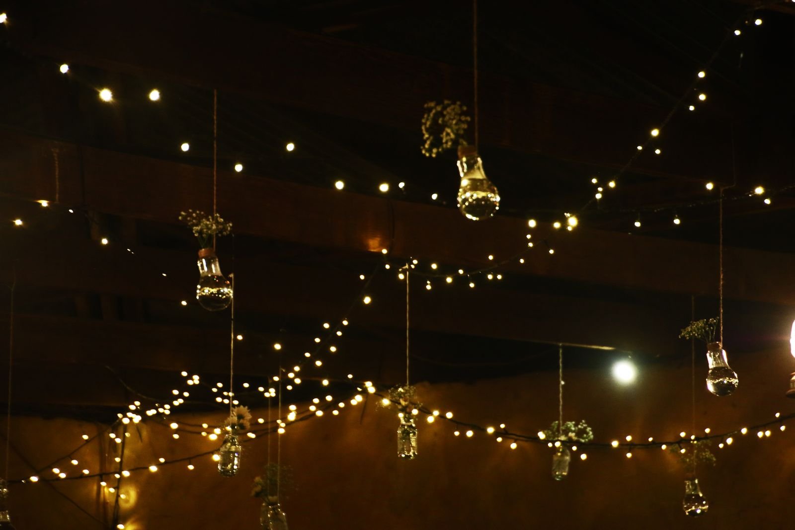 String lights and hanging jar lanterns casting a warm glow in a cozy room