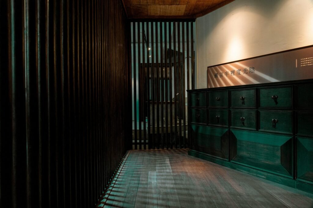 A stylish wooden interior featuring a dark cabinet and vertical slatted divider.