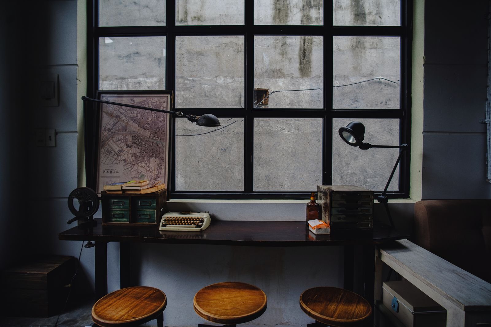 Vintage-style workspace with a typewriter, a map and an industrial window