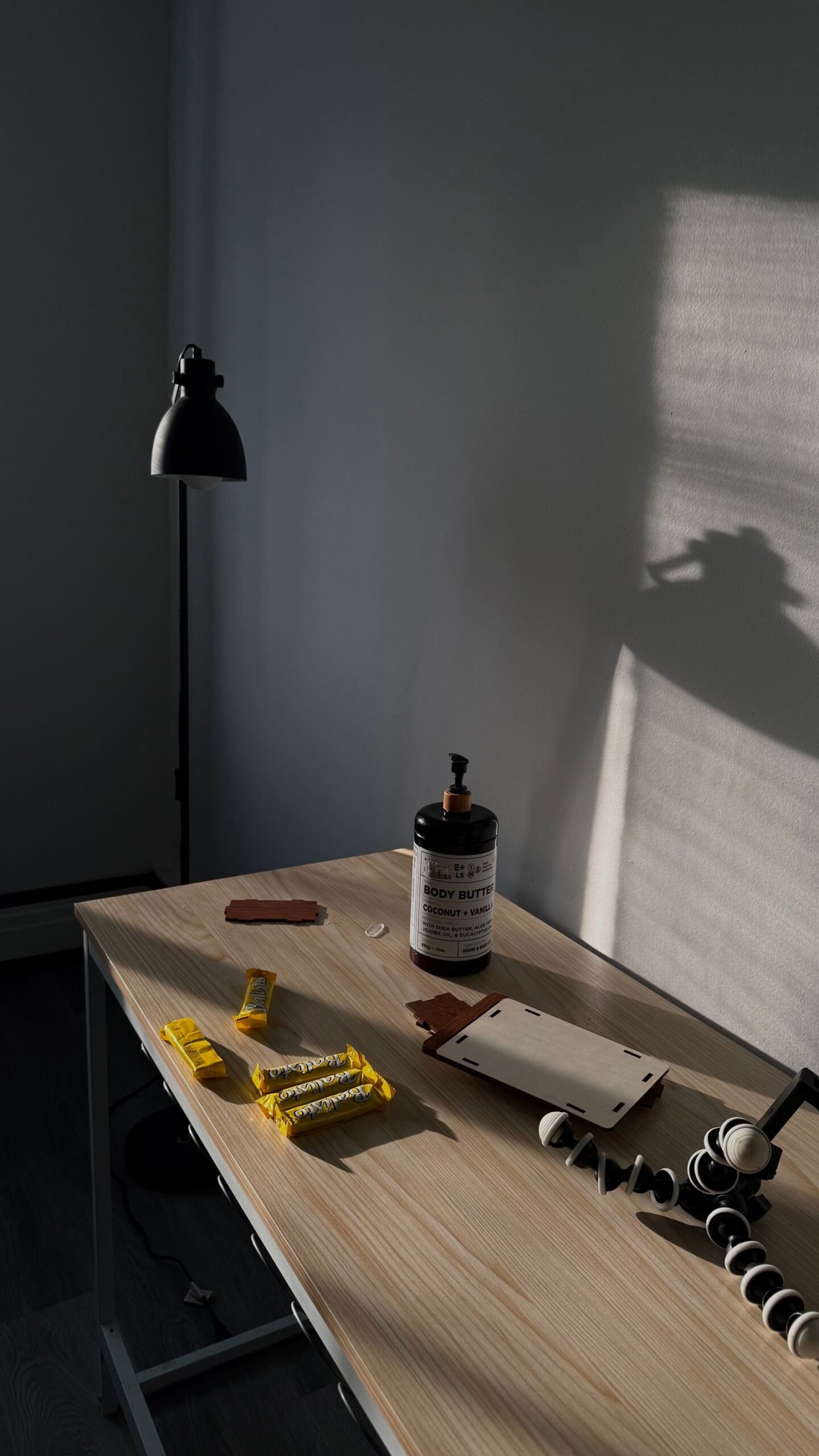 Clean minimalist desk with a lamp and neatly arranged stationery in daylight