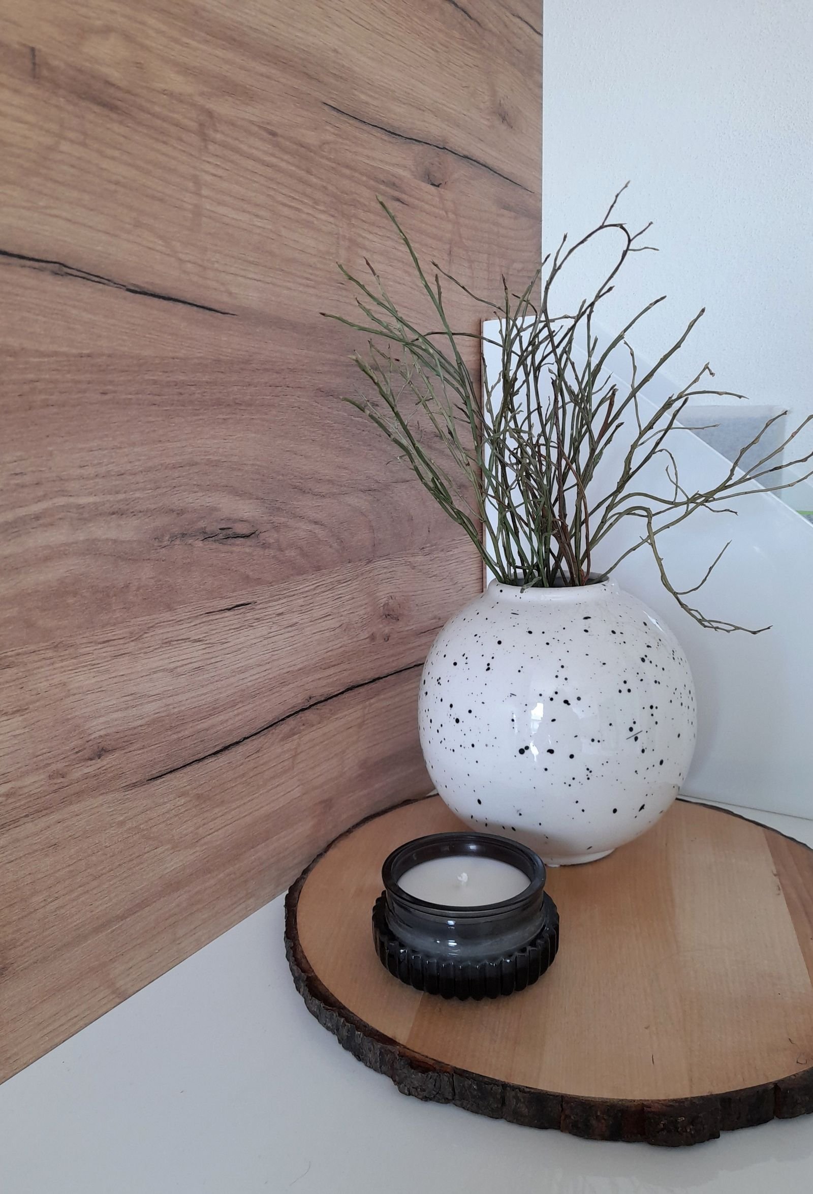 Wooden decorative tray holding a ceramic vase with branches