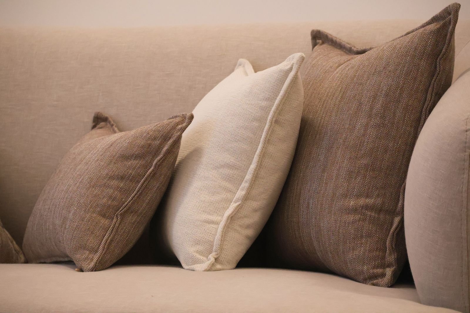 Sofa with brown and beige throw pillows in a warm living room