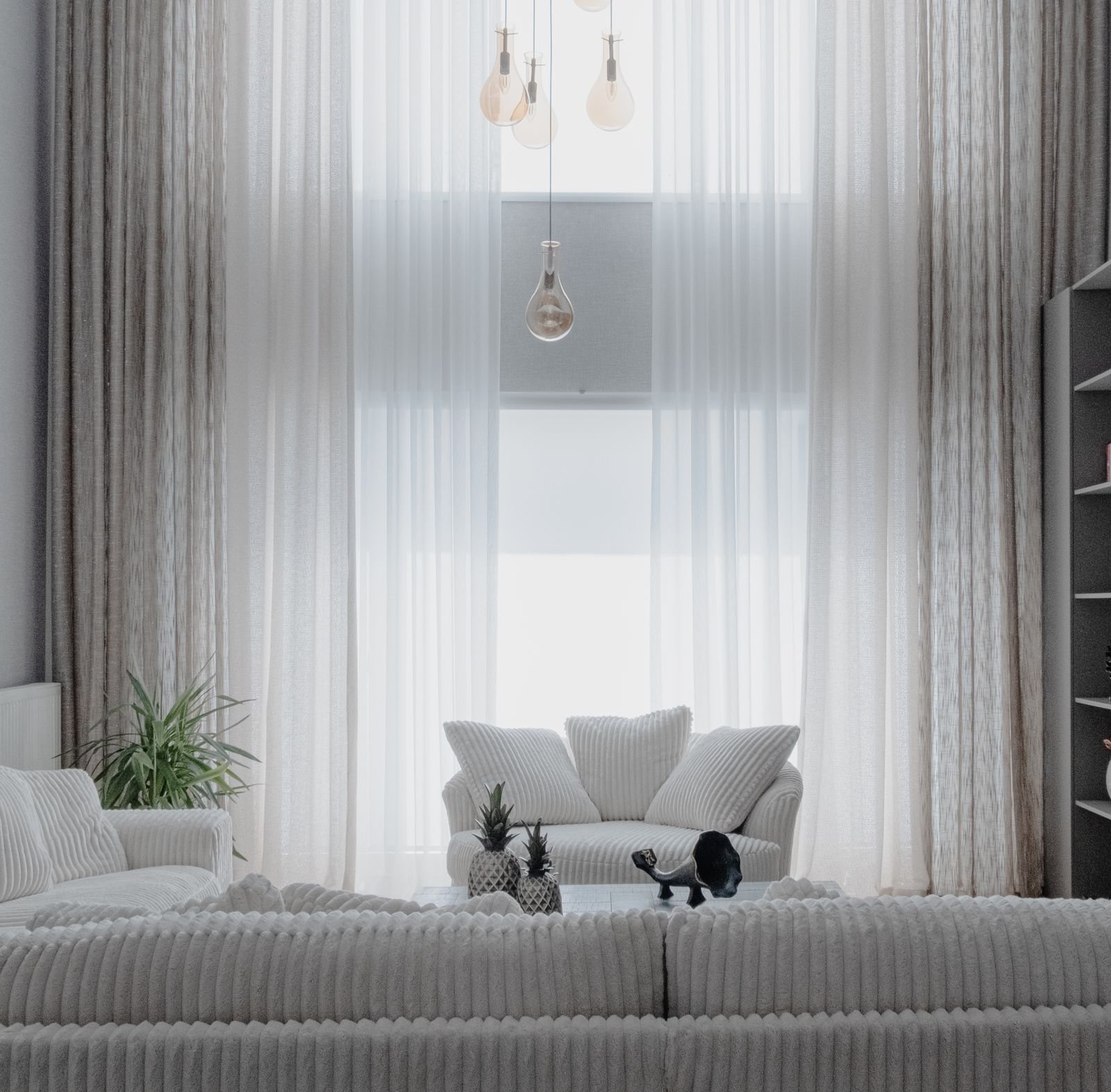 Calm living room with soft white sofas and large curtains in a minimalist space