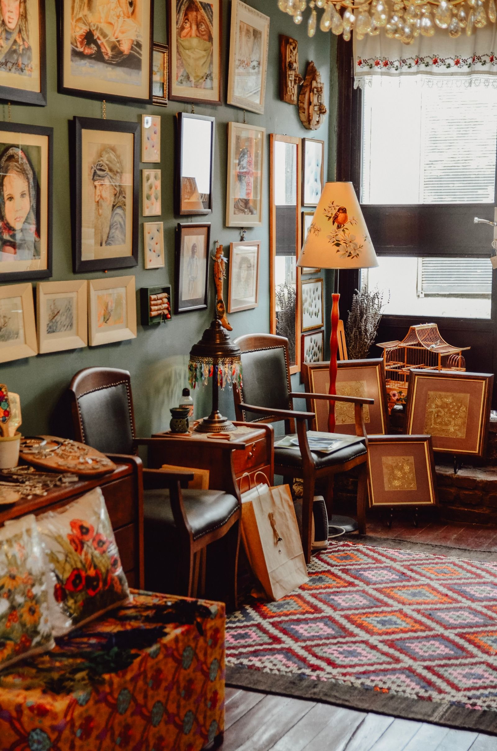 Maximalist living room filled with antiques, art pieces and layered decor in natural light