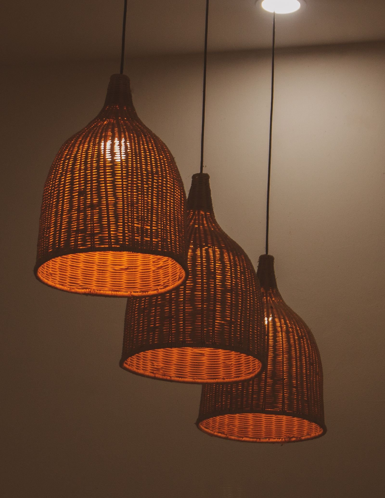Three matching wicker pendant lamps in a row showing rhythm through repetition