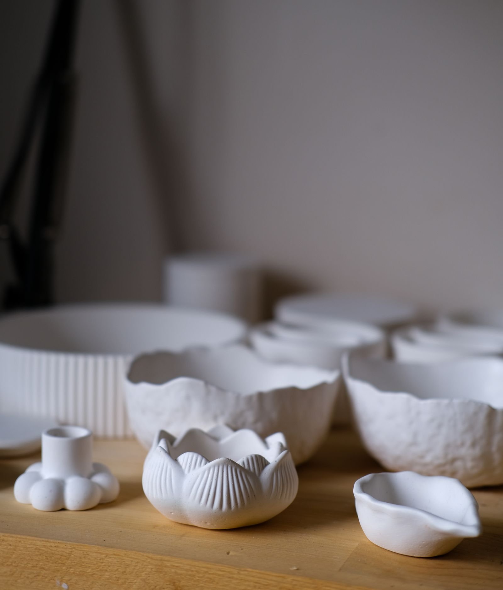 Handmade white ceramic bowls on a wooden surface