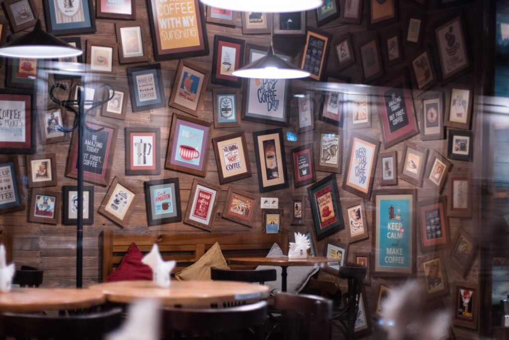 A cozy café interior featuring a decorative wall with framed coffee-themed art, creating a warm and inviting atmosphere.
